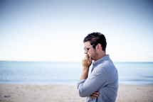 man standing on a beach thinking 