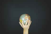 hand holding up a globe