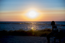 woman watching the sunset over the ocean 