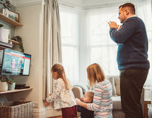 family clapping to music watching an online worship service 
