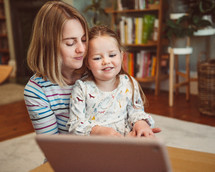 a mother and child making a video call on a laptop 