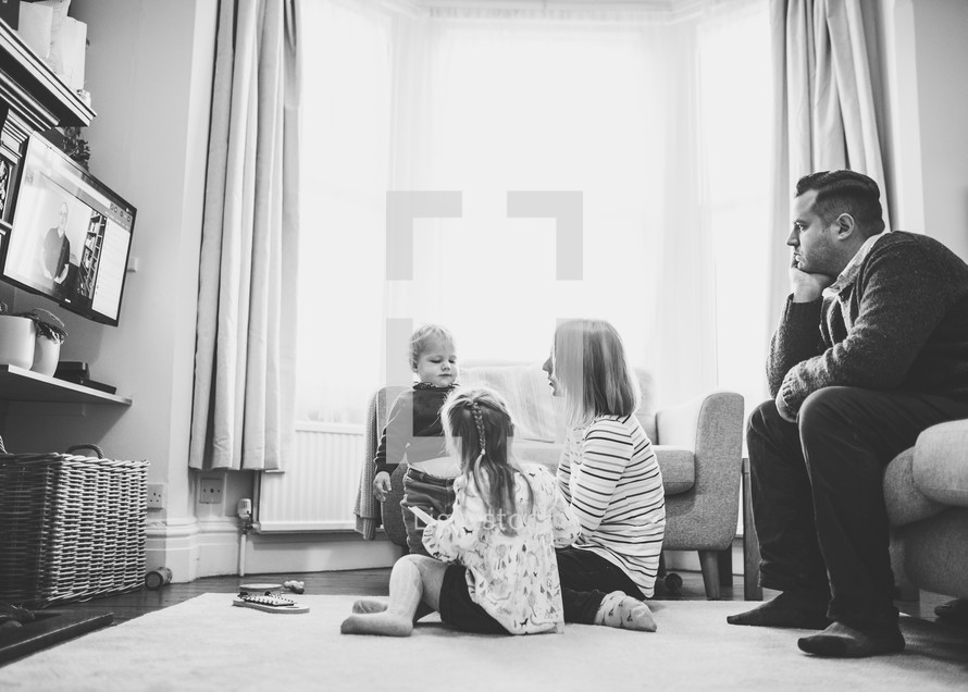 a family watching a worship service at home on their TV
