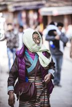 woman holding prayer beads in Tibet 