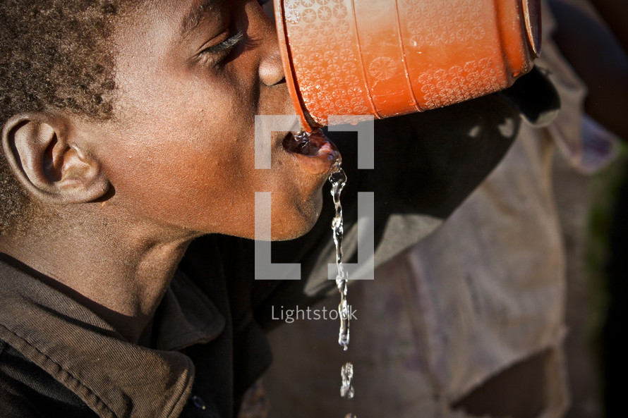 Boy drinking water from a bowl