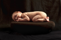 naked newborn on a pillow