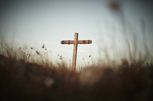A cross in a grassy field on a hilltop