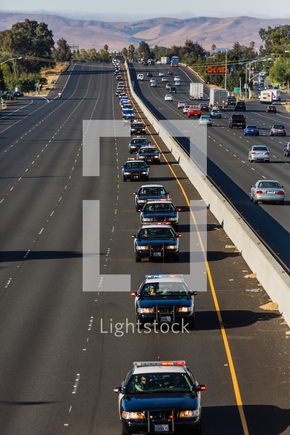 line of police cars on a highway, funeral procession 