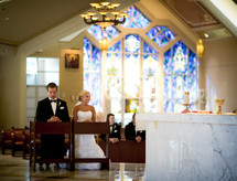bride and groom kneeling in prayer at an altar during rehearsal 