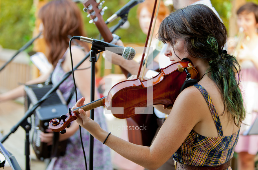 woman in a band playing a violin