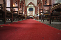 Red carpet running down cathedral aisle lined with wooden pews.