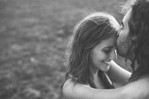 a man plants a tender kiss on a woman's forehead 