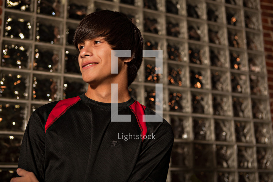 young man standing by glass brick wall