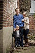 Family standing by a brick wall.