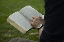 Man reading the Bible in a park