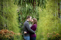 couple kissing in a greenhouse 
