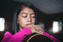 a girl child praying over a guitar 