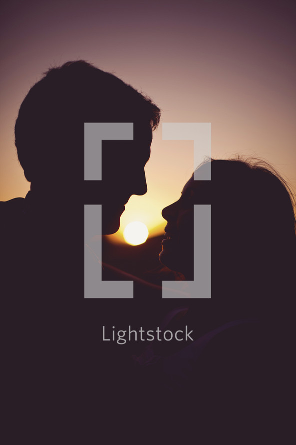 The silhouette of a couple holding each other at sunset 