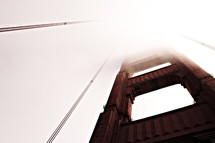 A close up of the Golden Gate Bridge covered in fog