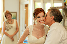 father kissing his daughter bride before a wedding