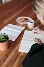 a woman reading a Bible and journaling 