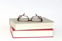 reading glasses on a stack of books 