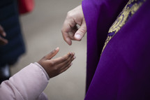 priest shaking a child's hand 