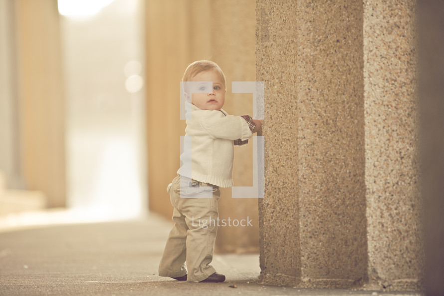 toddler walking up to a pillar