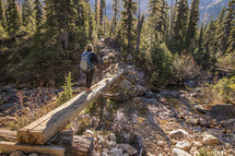 crossing a wooden beam over a stream 