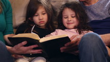 grandparents reading a Bible with their grandkids 