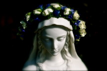 crown of roses on a statue of Mary