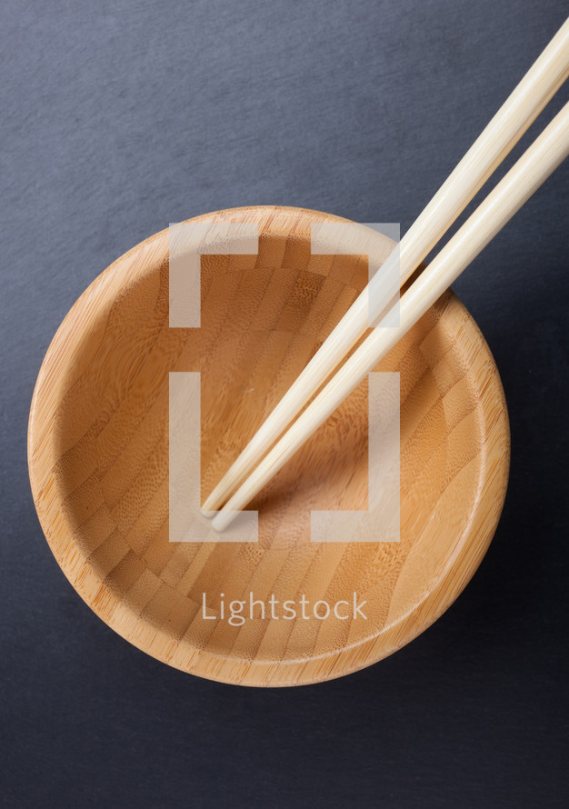 chopsticks with empty wooden bowl 
