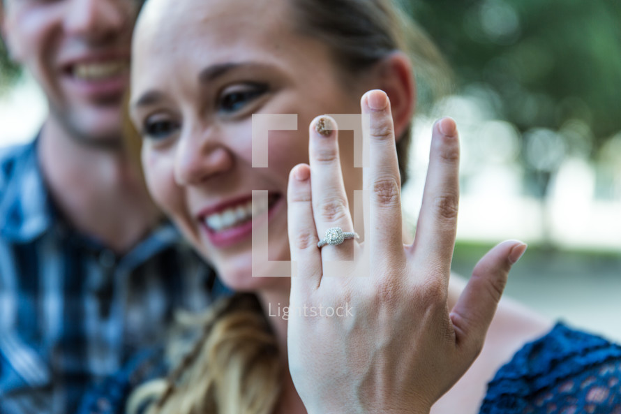 a woman showing off her engagement ring 
