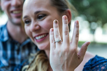 a woman showing off her engagement ring 