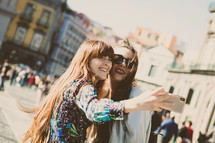 Two young adults take a selfie in Piazza del Plebiscito in Naples.