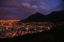 Night Time and City Lights at the foot of a mountain range  