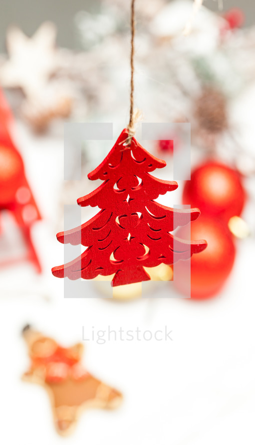 Red wooden Christmas sapling on blurred background with Christmas objects.