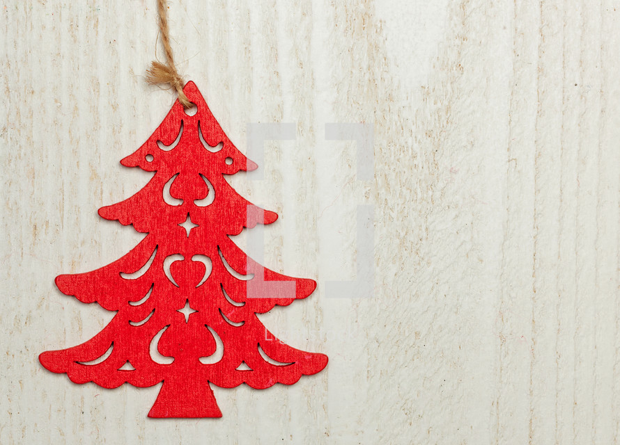 Red wooden Christmas sapling on white wood background. 