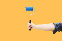 arm holding out a paint roller 