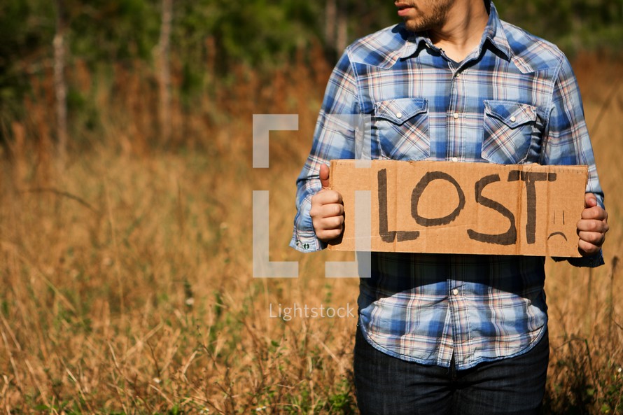 Man holding "Lost" cardboard sign