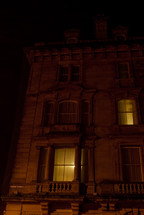 lights on in the windows of a city townhouse