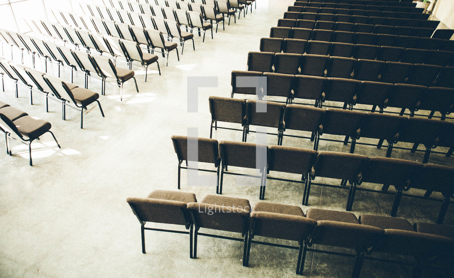 church nave between empty rows of chairs 
