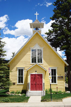 Small yellow church with red doors