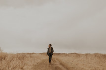 a man walking on a dirt road 