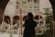 a woman taking a picture of a courtyard 