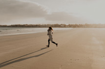 a woman running on a beach 