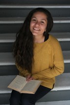 smiling young woman reading a book 