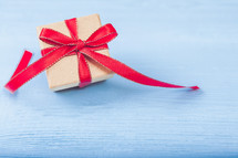 red ribbon around a gift box on a blue background 