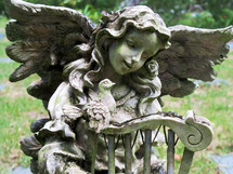 A statue of an Angel and a bird fellowship together at a pet cemetery reminding us that death is not the end or final chapter but a passing from this life to the eternal life where there is no more death, no more crying, no more sickness and no more pain. 