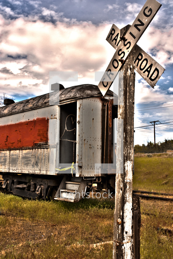 A railroad crossing sign in front of a train