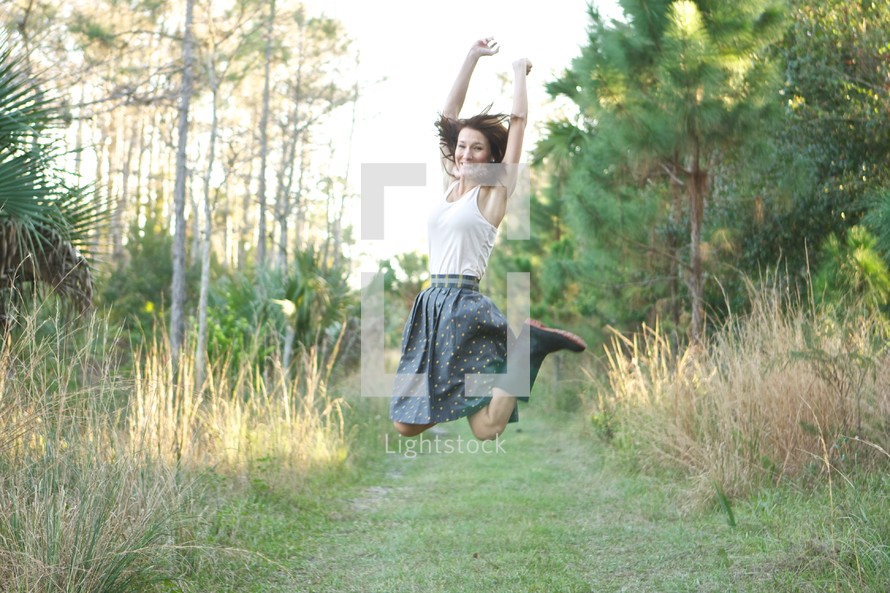 Woman jumping in mid air outdoors